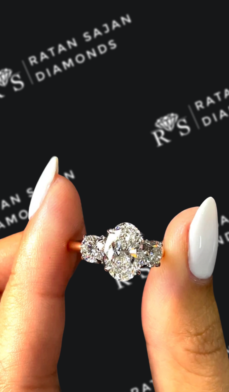 One-and-a-half carat oval natural diamond trilogy engagement ring