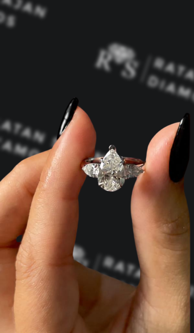 One-and-a-half carat pear shaped natural diamond trilogy engagement ring